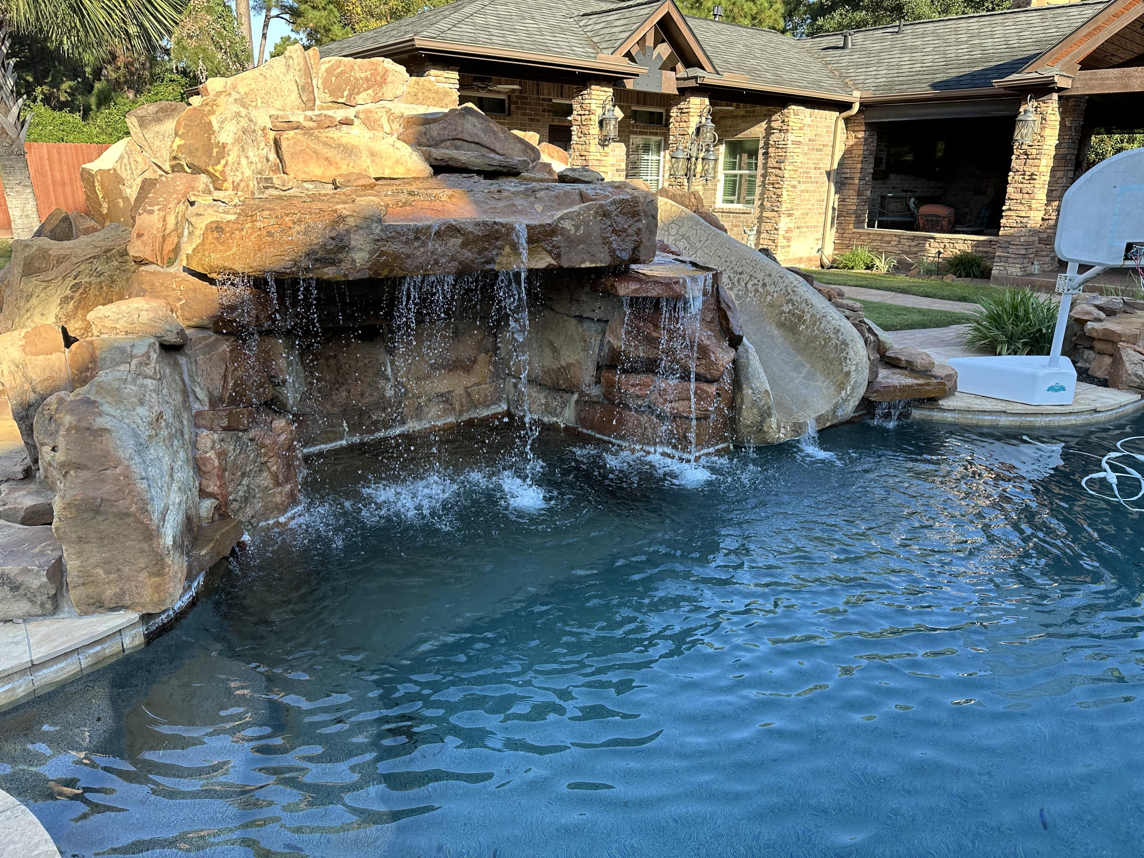 Crystal clear waterfall pool serviced by Bluecrest Pools in Tomball